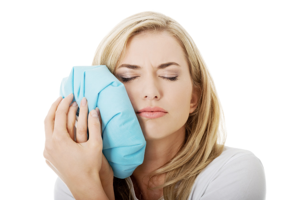 woman holding ice pack to face