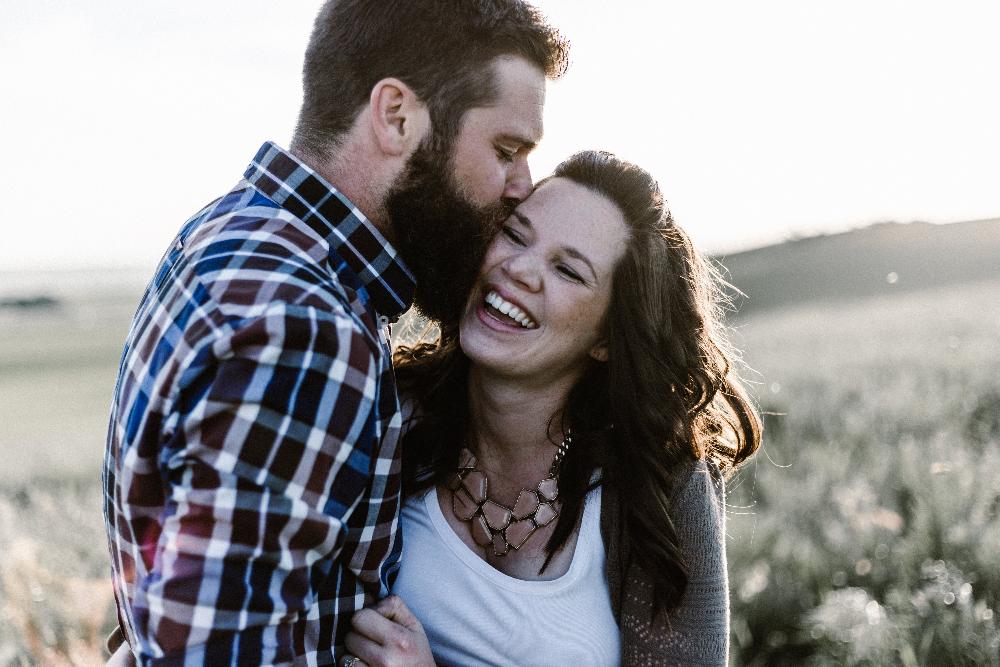 man kissing his wife's forehead 