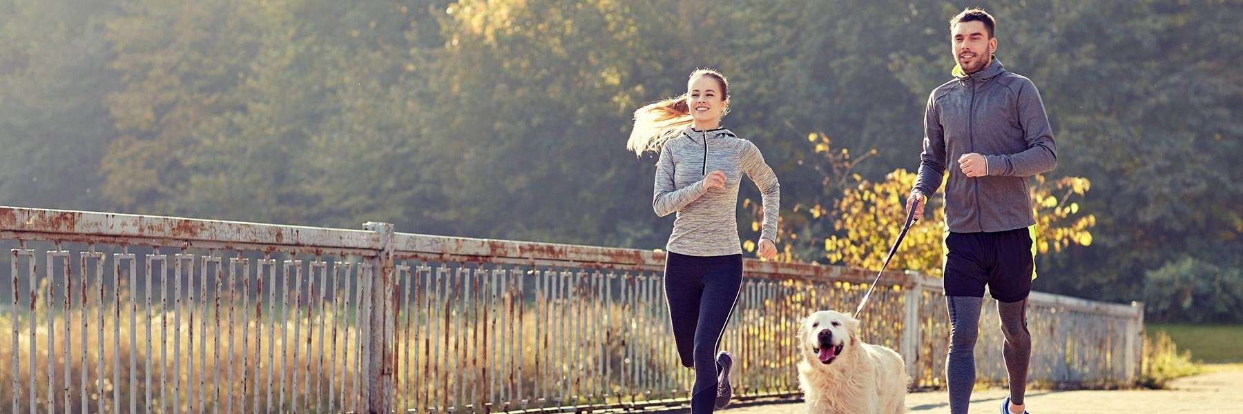 Couple running with their dog at Kangaroo Point Cliffs Park in Brisbane