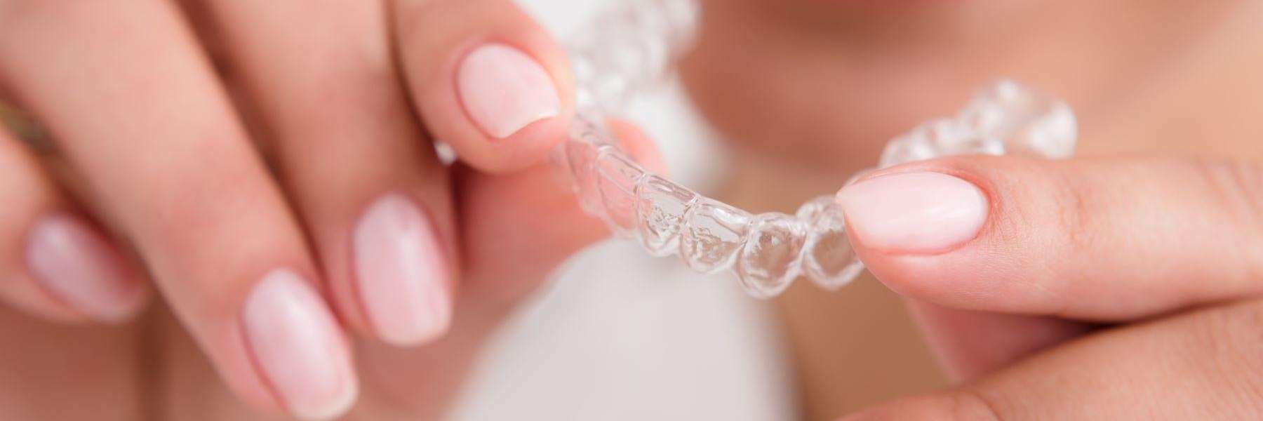 close up of person holding invisalign aligners 