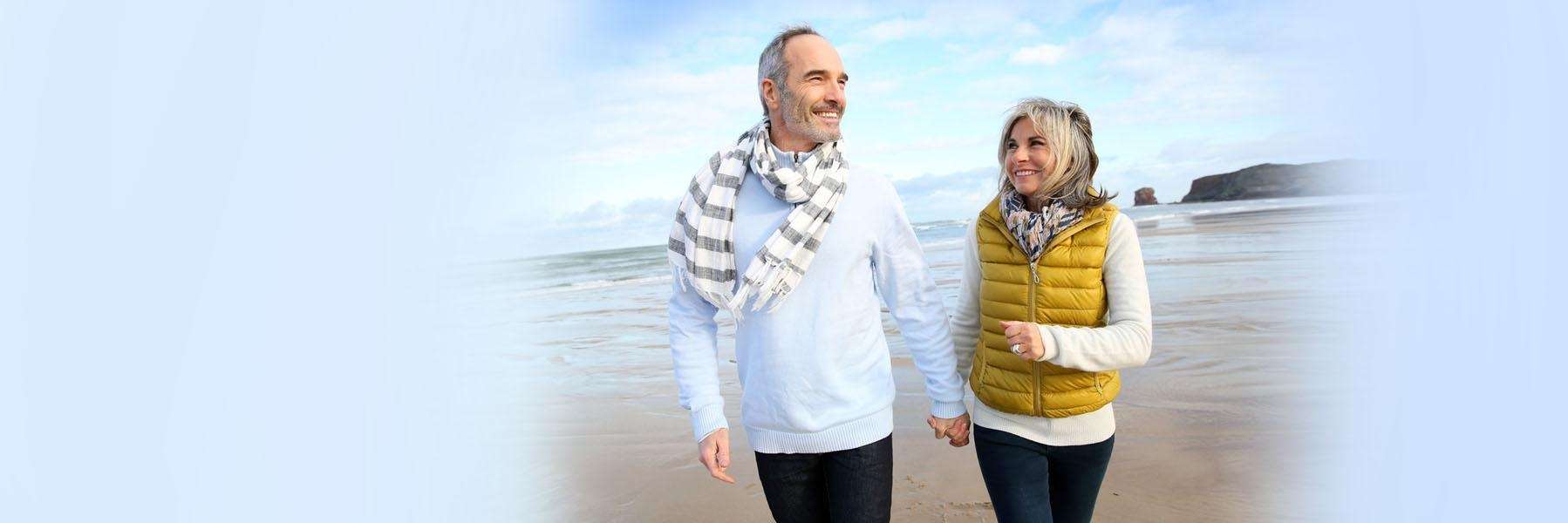 middle aged man and woman walking on the beach