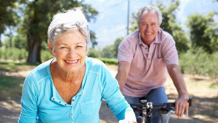 older man and woman riding bikes in the park in brisbane