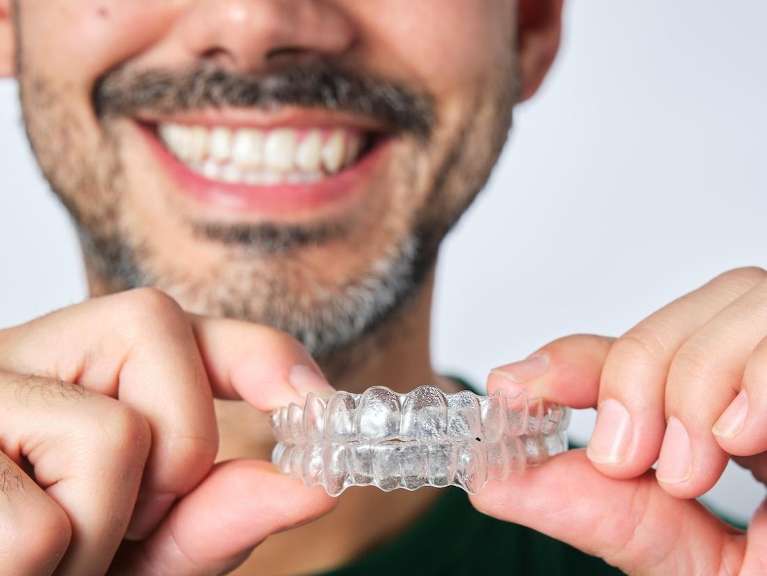 brisbane man holding invisalign aligners 