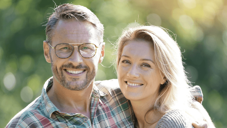 man and woman smiling in a park