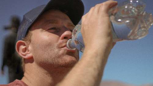 brisbane man drinking from water bottle during the summer