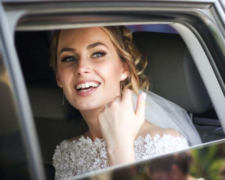 bride smiling in the car on the way to her wedding