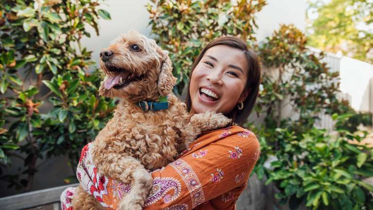 happy woman holding her dog in brisbane