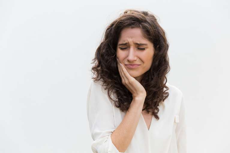 woman holding jaw from tooth pain before root canal