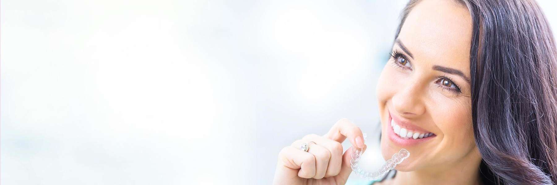 Patient holding tray of Invisalign at dentist in Brisbane CBD