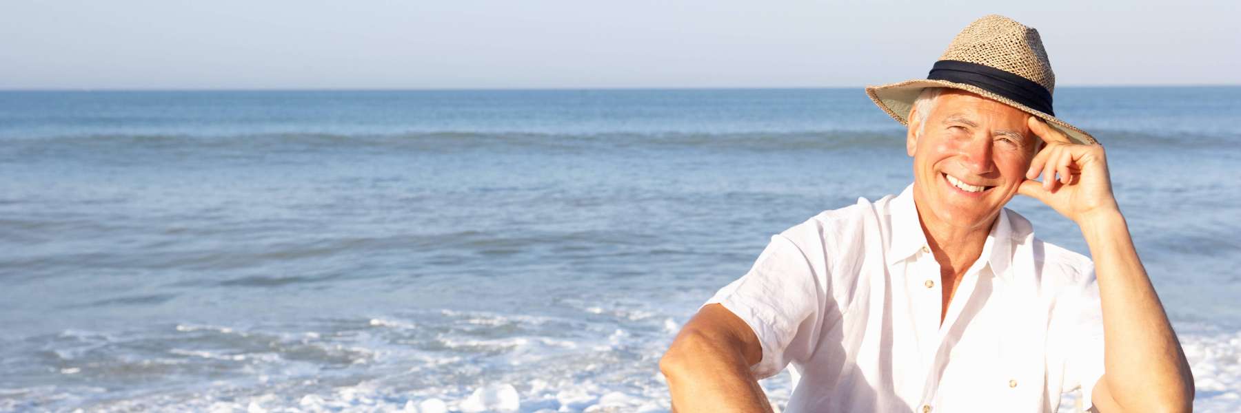 man with hat smiling on a Brisbane beach