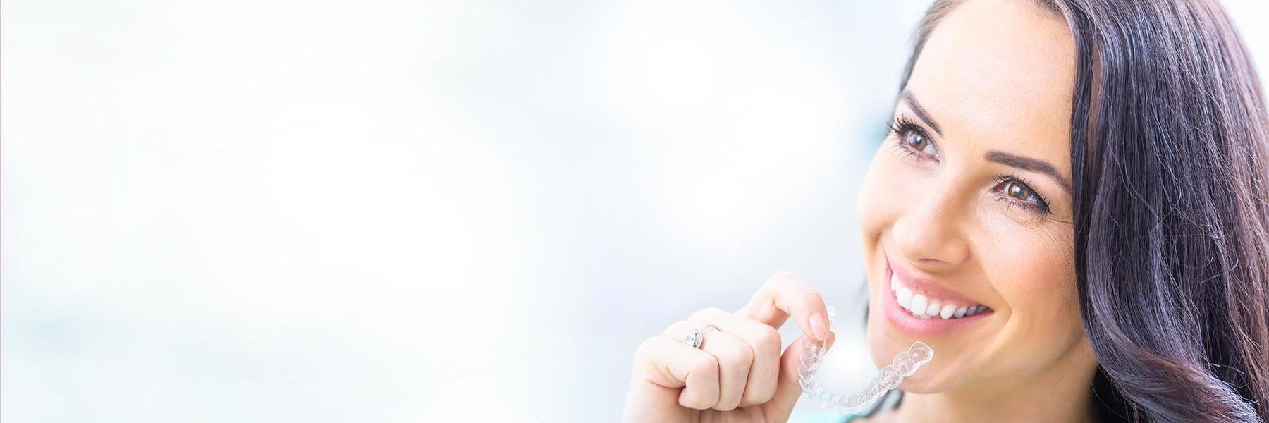 Woman holding tray of Invisalign in Brisbane