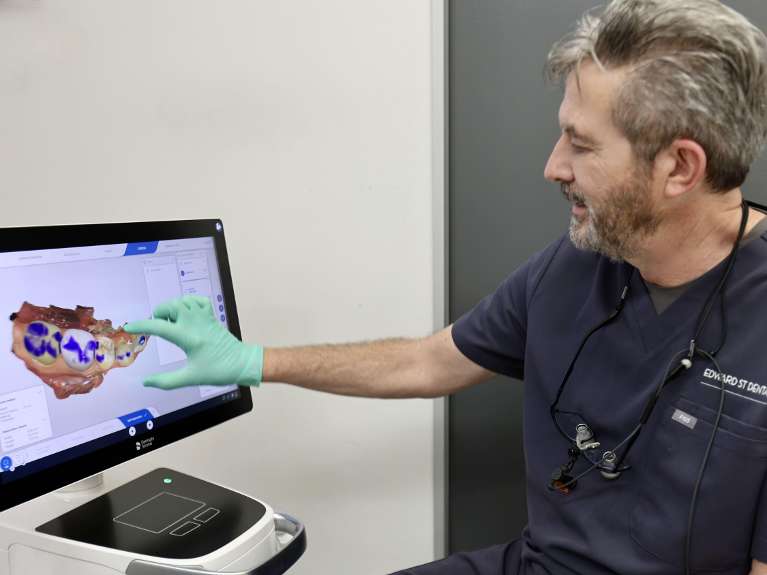 Dr Malcolm Campbell looking at a digital image during a smile design consultation